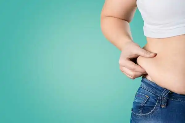 Image of woman pinching her love handles to show weight gain Solihull